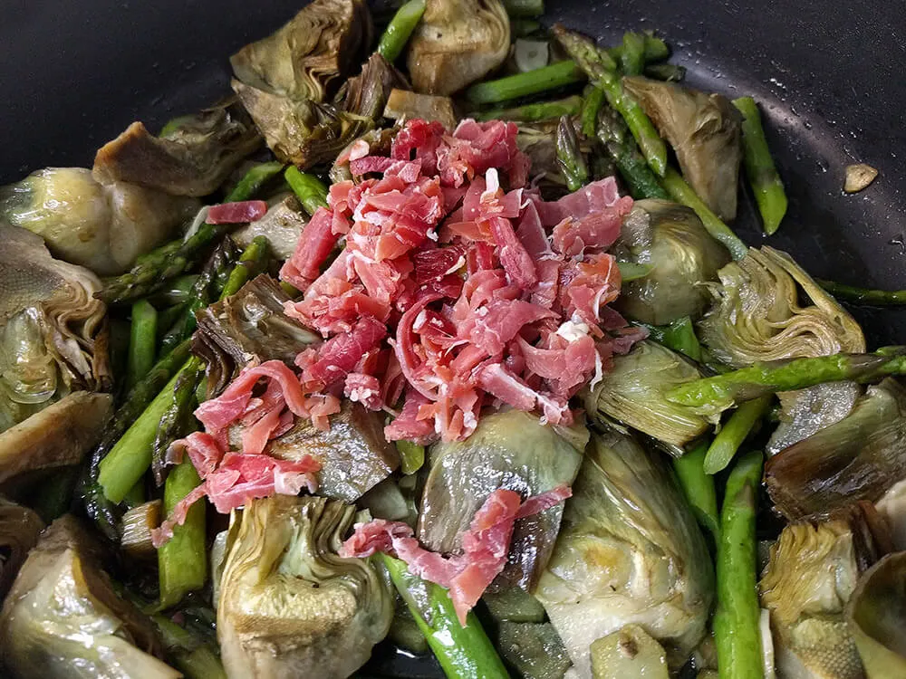 Alcachofas, espárragos y ajos laminados con jamón picado