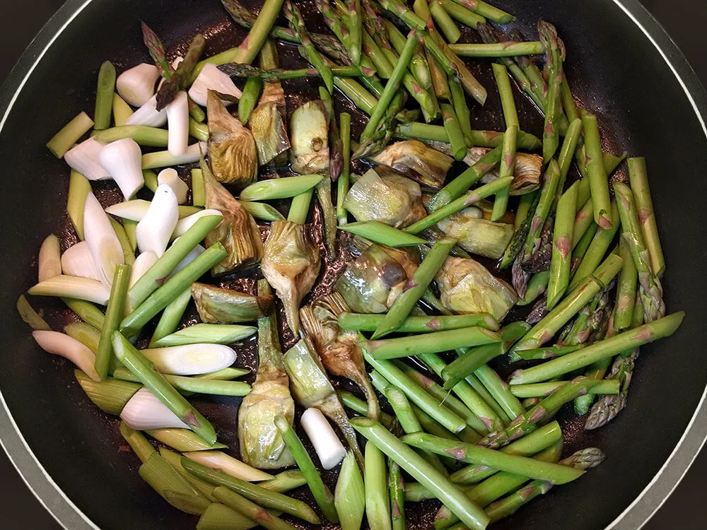 Espárragos, ajos tiernos y alcachofas rehogándose