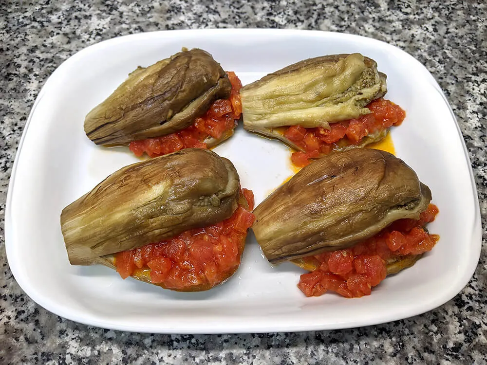 Berenjena horneada rellena con sofrito de tomate.