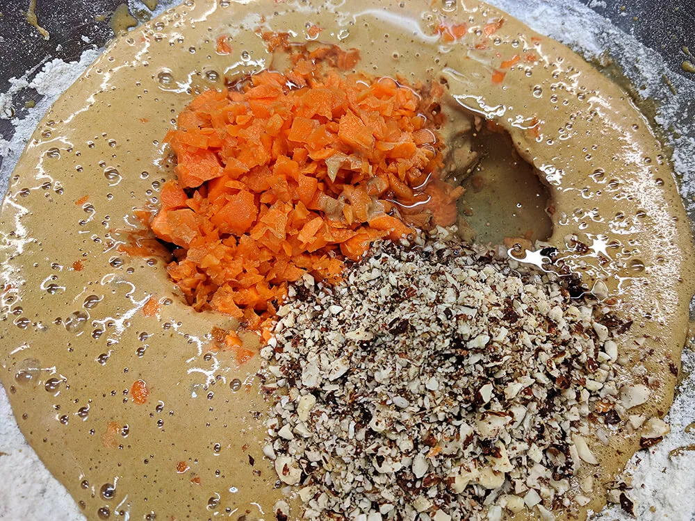 Huevos batidos con azúcar, harina y levadura con zanahoria y avellanas picadas.