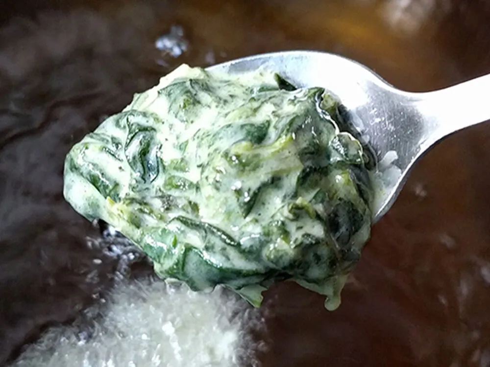 Porción de buñuelo de espincas listo para freir