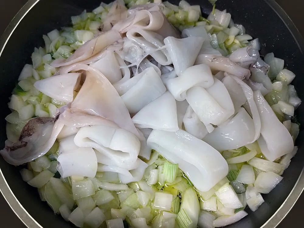 Cebolla rehogada con calaramares crudos a rodajas