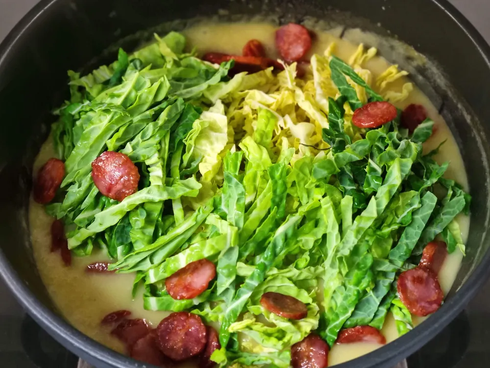 Caldo, patatas, cebolla, ajo, col y chorizo.