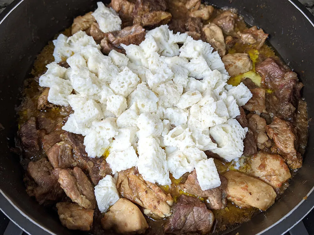 Carne y dados de pan en leche.