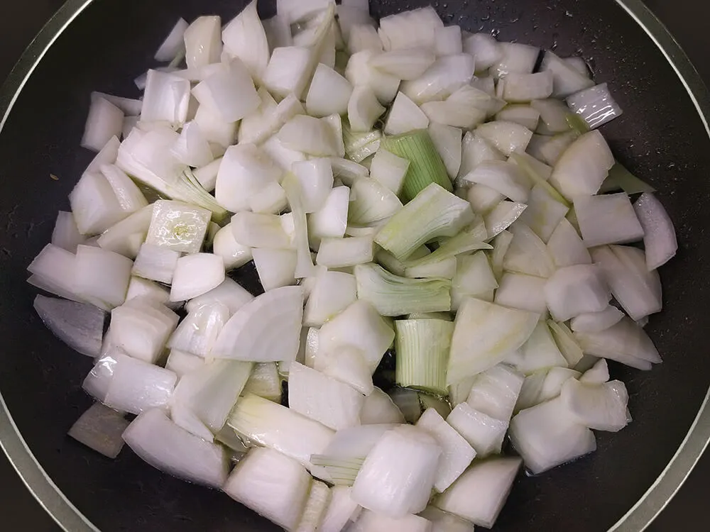 Cebolla cortada a trozos grandes en una sartén