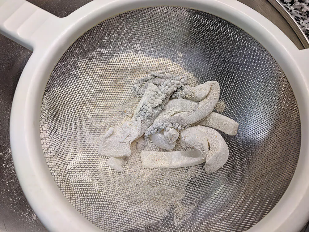 Sepia rebozada en colador.