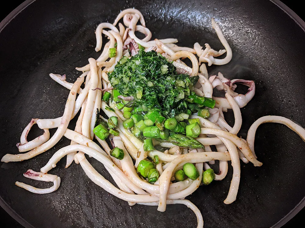 Espárragos y calamares salteados con aceite de ajo y perejil.