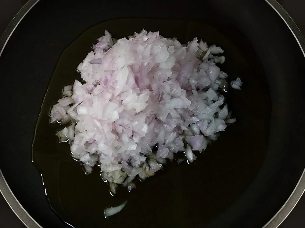 Cebolla picada en sartén con aceite de oliva.