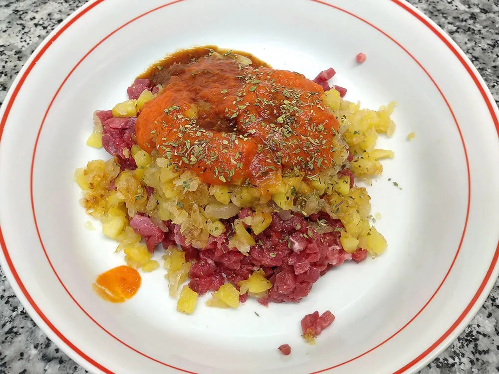 Carne picada, sofrito de cebolla y manzana, salsa Perrins, orégano y sofrito de tomate.