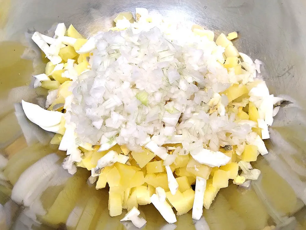 Patata y huevos cocidos, cebolla picada.