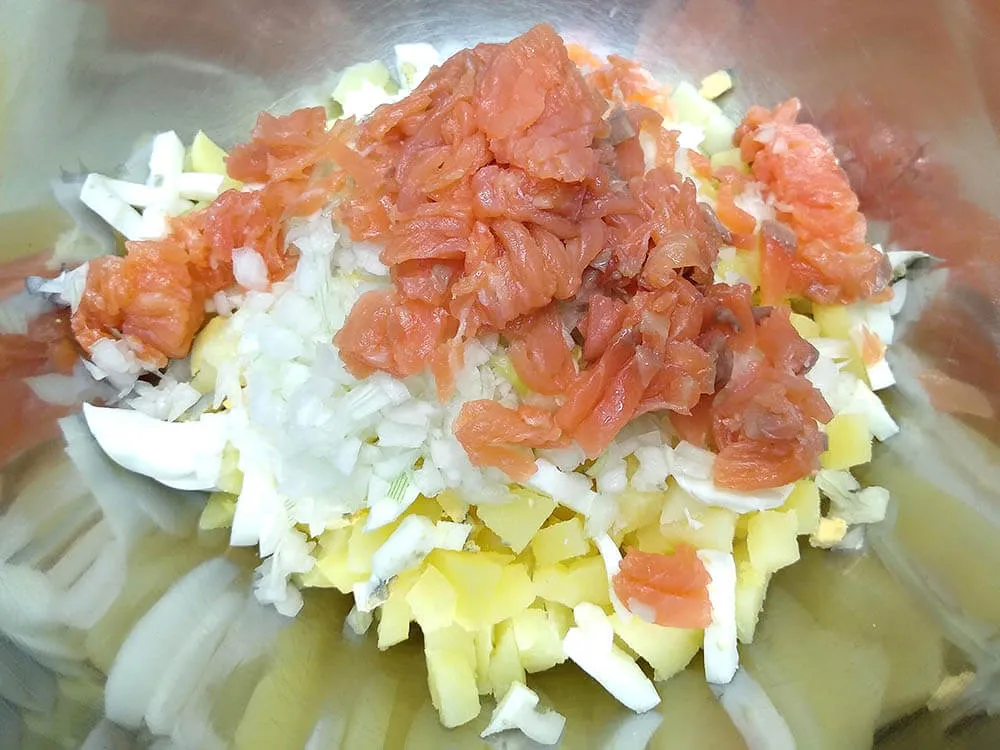 Patata y huevos cocidos, cebolla picada y salmón ahumado a tiras.