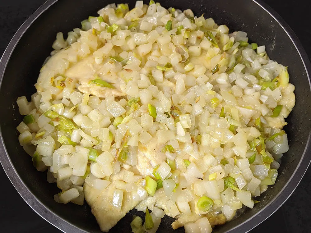 Pollo enharinado frito y pera y ajos salteados.