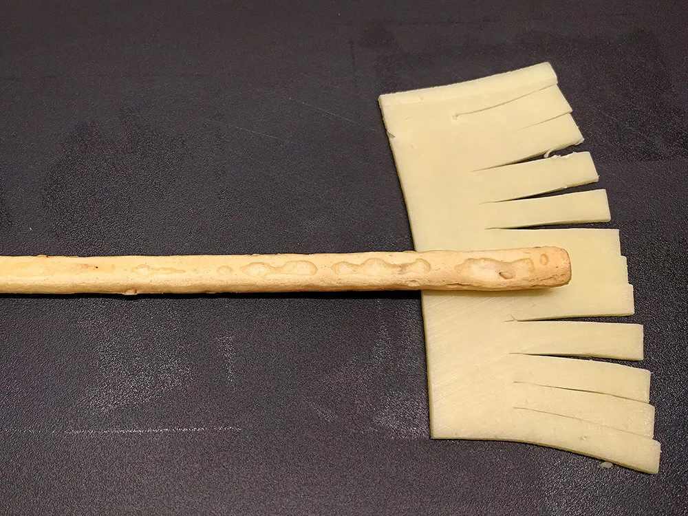 Bastoncito de pan y queso Gouda cortado.