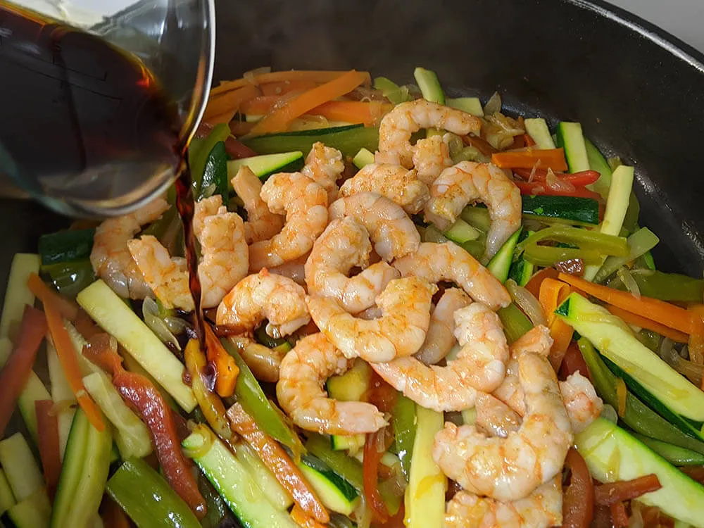 Pimientos verde y rojo, zanahoria, cebolla, calabacín y langostinos.