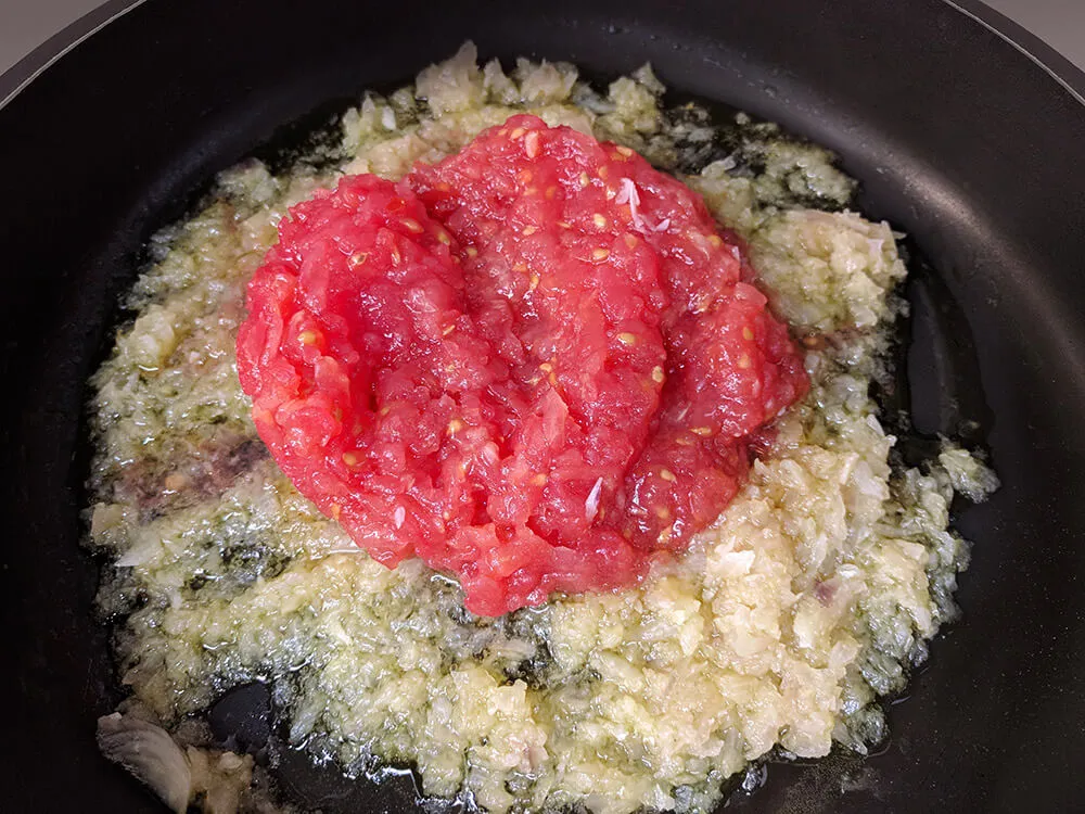 Sofrito de cebolla y tomate rallado.