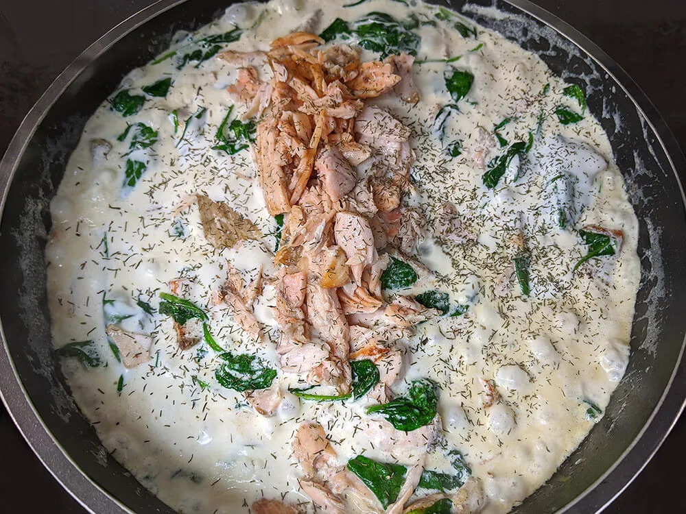 Dados de salmón, espinacas baby, nata y salmón desmigado.