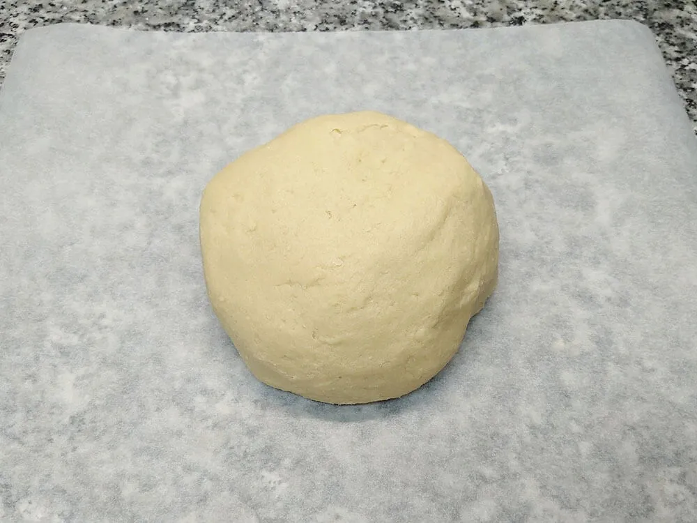 Masa de las galletas de mantequilla encima de papel de hornear.