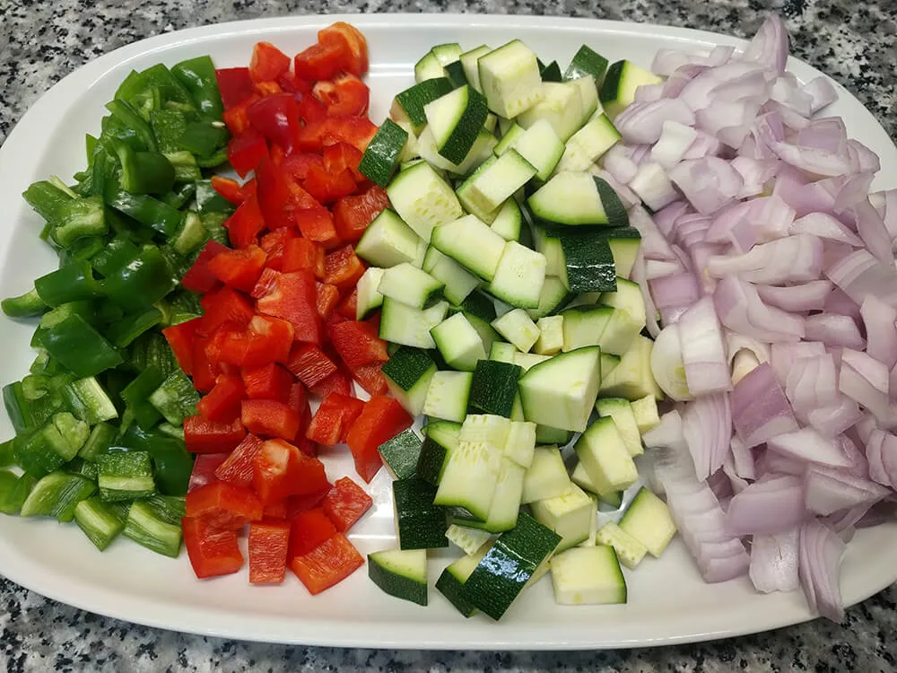 Cebolla, calabacín y pimiento verde y rojo cortados a macedonia grande