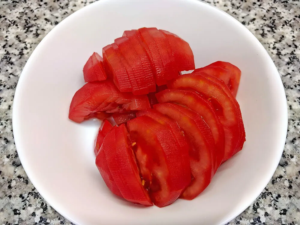 Tomates de pera cortados a medias lunas.