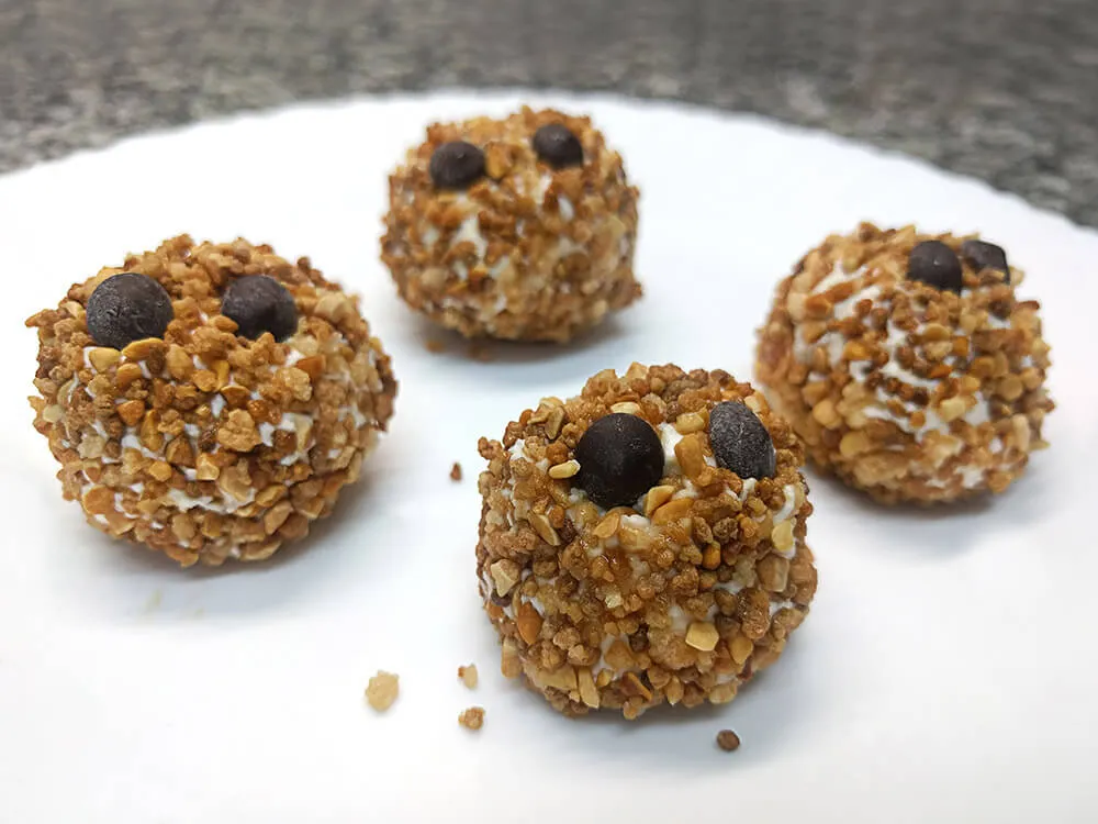 Bola de queso cremoso rebozada con crocanti y perlitas de chocolate.