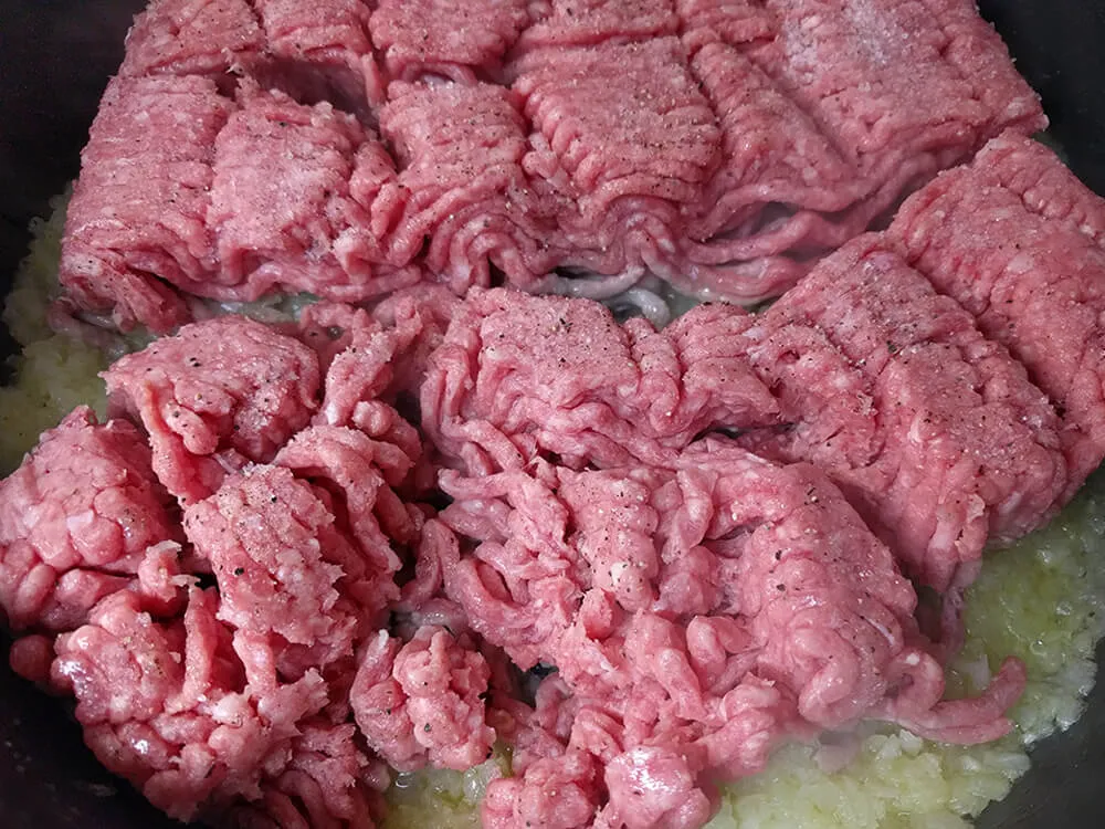 Cebolla pochada con carne picada cruda