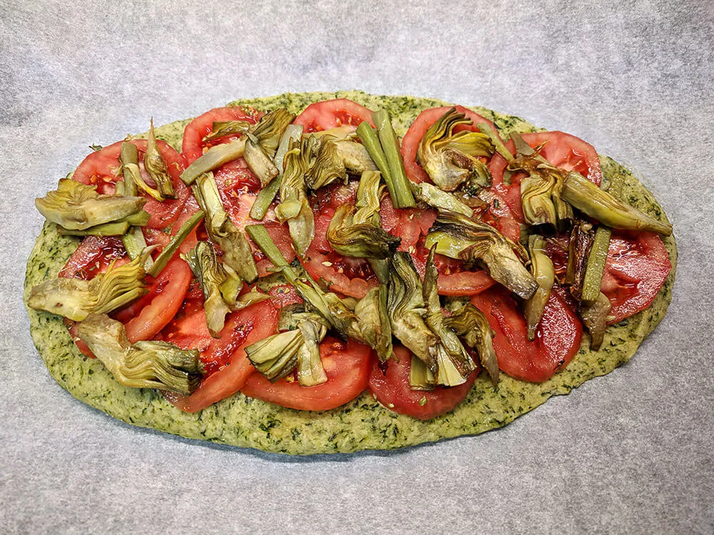 Pan kale con rodajas de tomate de pera y alcachofas.