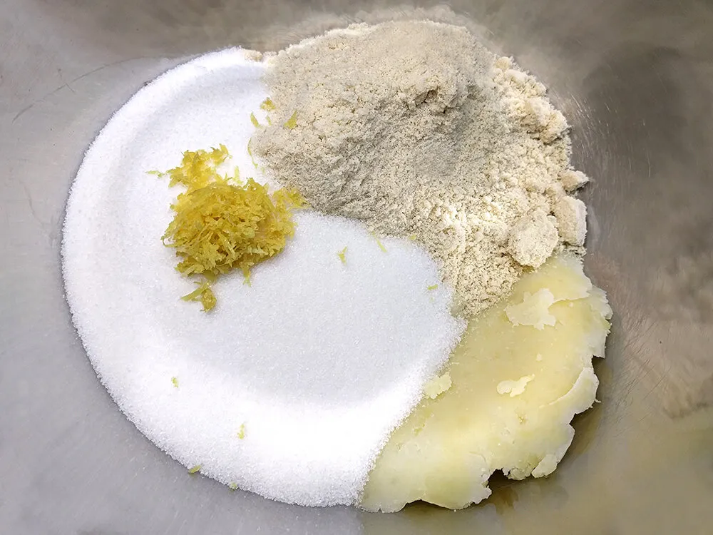 Puré de patata, almendra molida, azúcar y limón rallado.