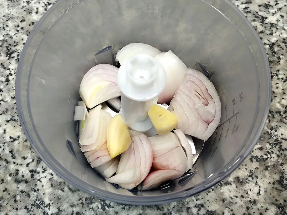 Cebolla y diente de ajo en picadora.