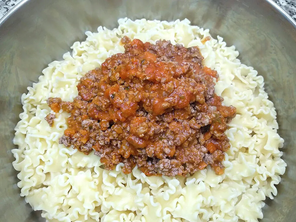 Pasta hervida y salsa boloñesa.