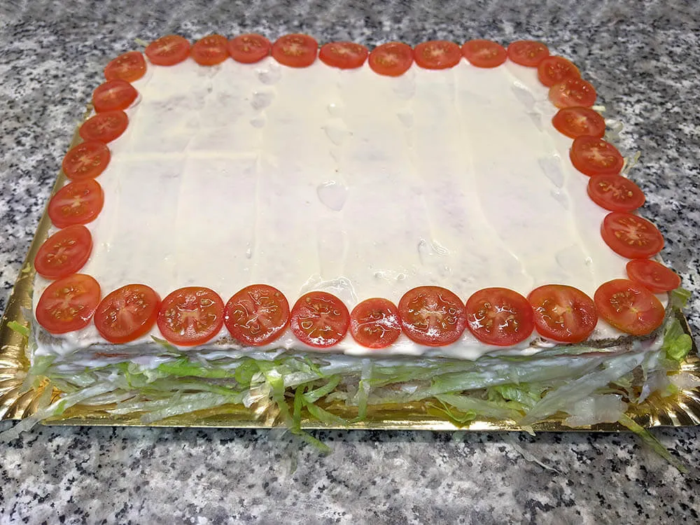 Pastel de pan de molde untado con mayonesa.