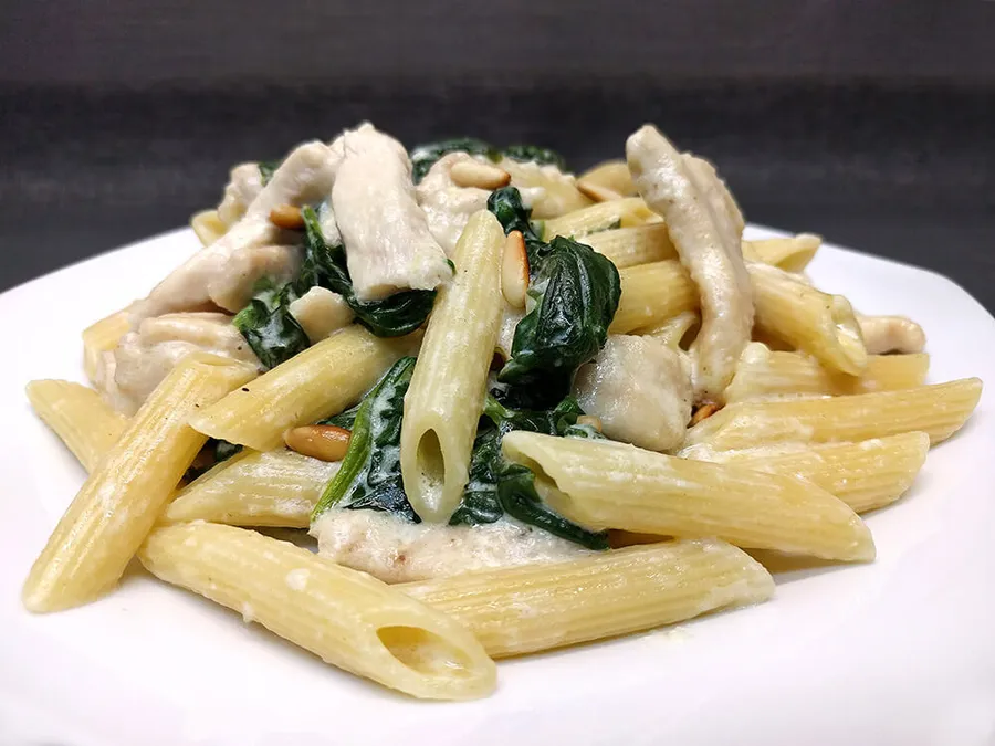 Penne rigate con espinacas, pollo y piñones