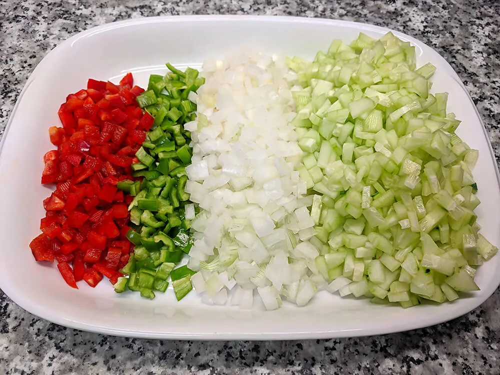 Pepino, pimiento verde, pimiento rojo y cebolla tierna cortados a dados.
