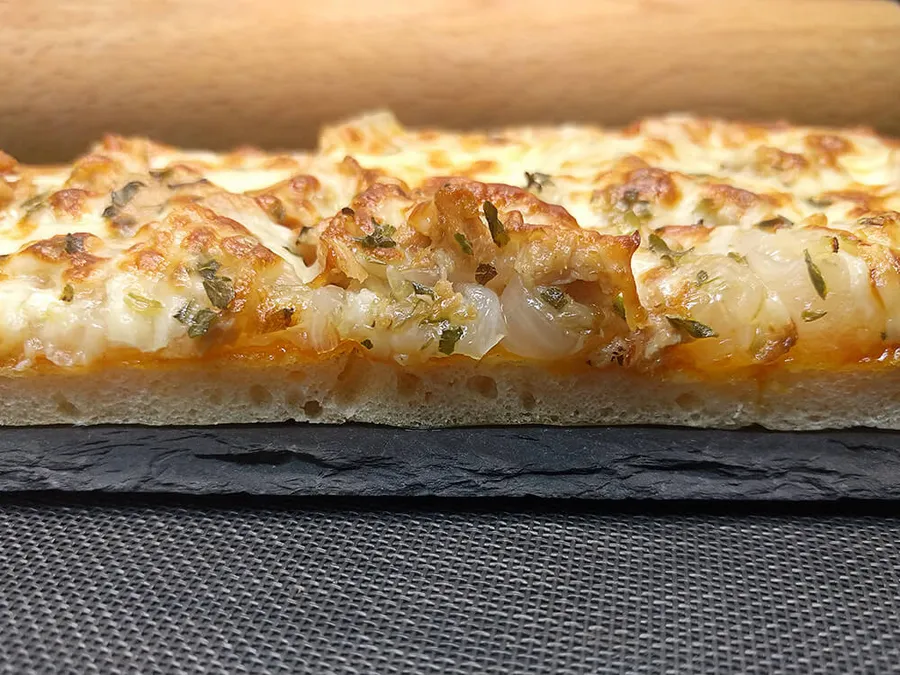 Presentación de la pizza de cebolla, mozzarella y atún.