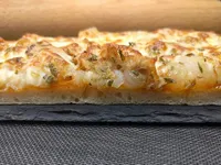 Presentación de la pizza de cebolla, mozzarella y atún.