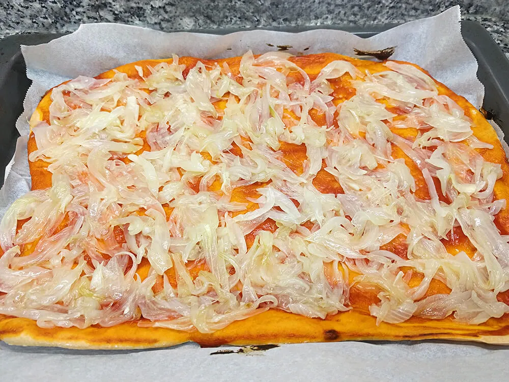 Base de pizza con cebolla frita.