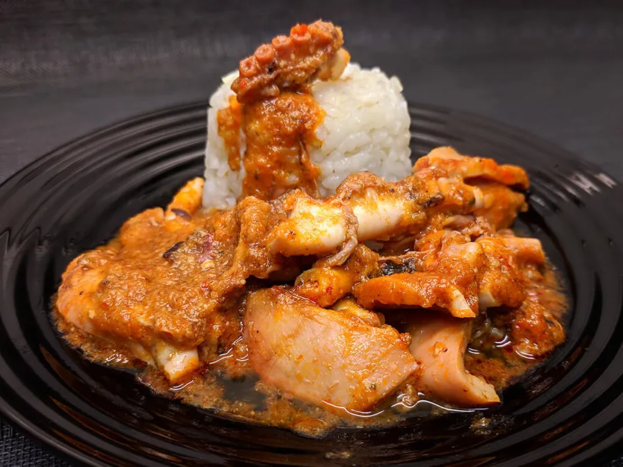 Pulpo en salsa con arroz.