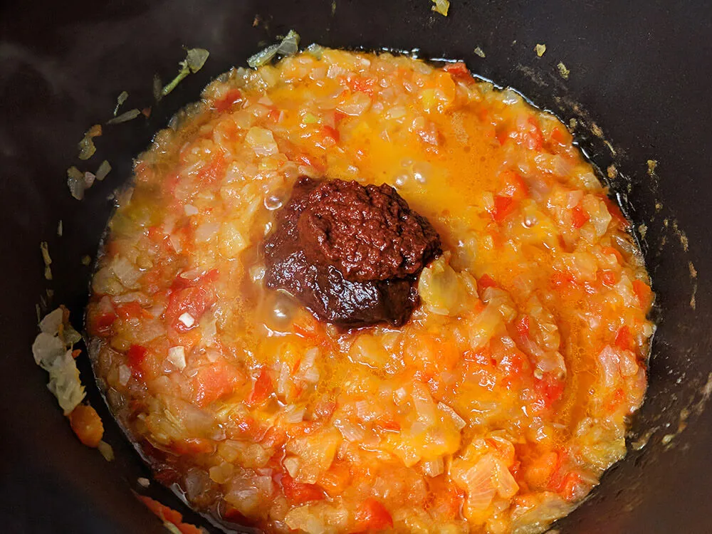 Pimiento y cebolla picados, tomate rallado y carne de pimiento choricero.