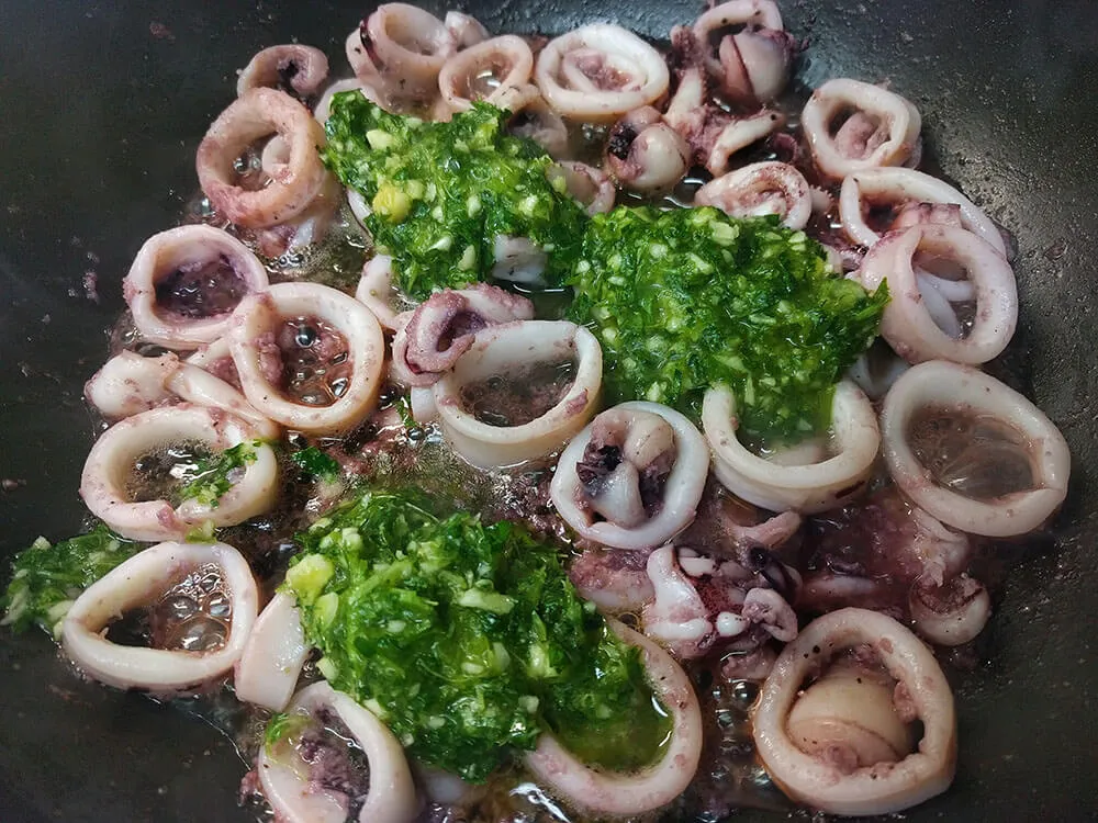 Chipirones salteados y ajo con perejil.