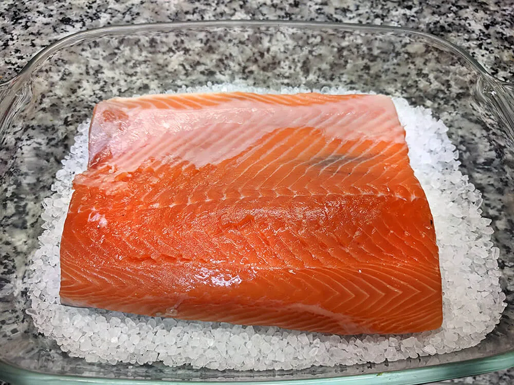 Salmón fresco en cama de sal gruesa.