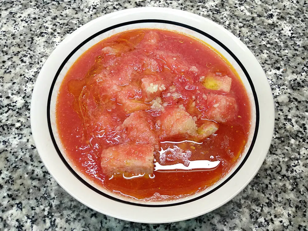 Tomate rallado, miga de pan, aceite de oliva, vinagre, sal y diente de ajo picado.
