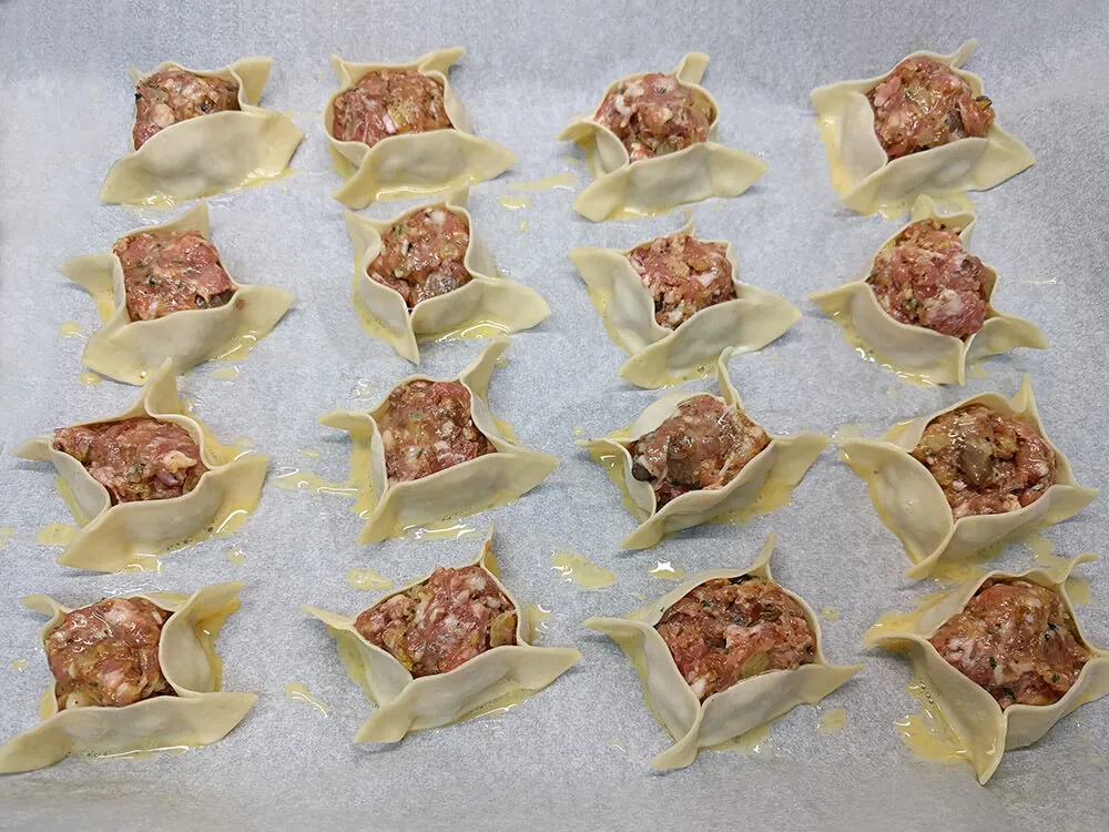 Saquitos en bandeja de horno pintados con huevo batido.