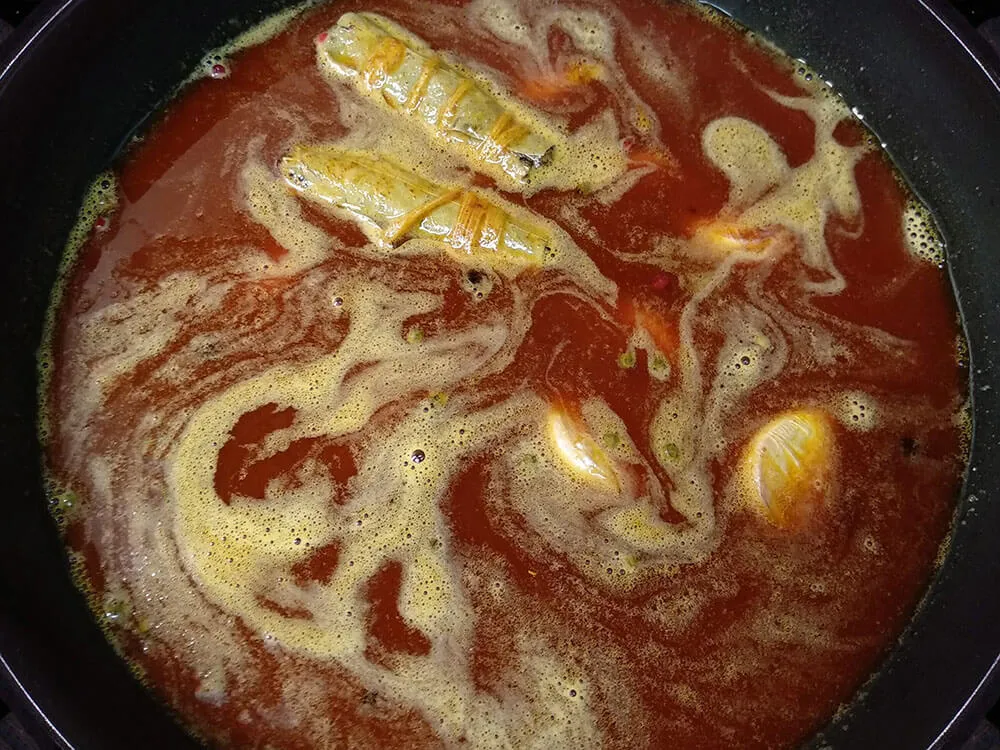 Sartén con aceite de oliva, pimienta, dientes de ajo, laurel, tomillo, pimentón, vinagre y agua.