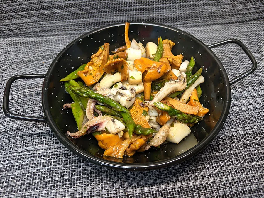 Presentación de la sepia con rebozuelos y espárragos.