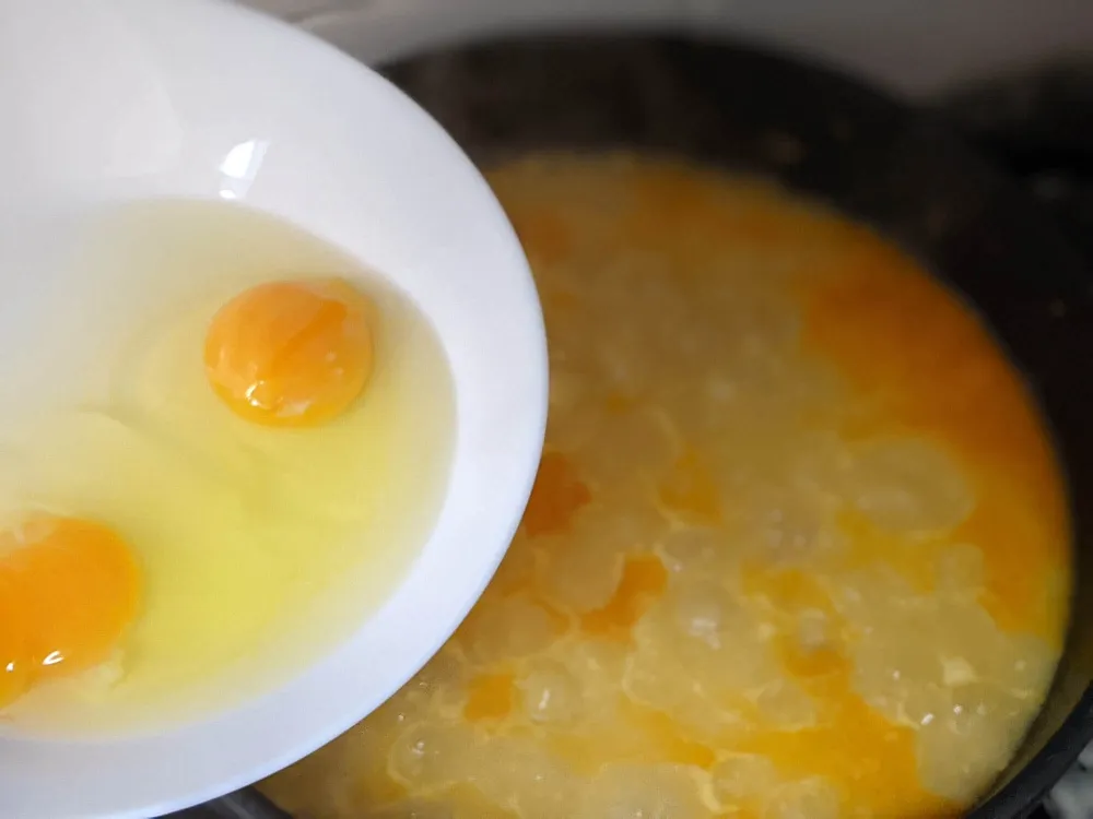 Daditos de pan, ajo chafado, pimentón, caldo y huevo.