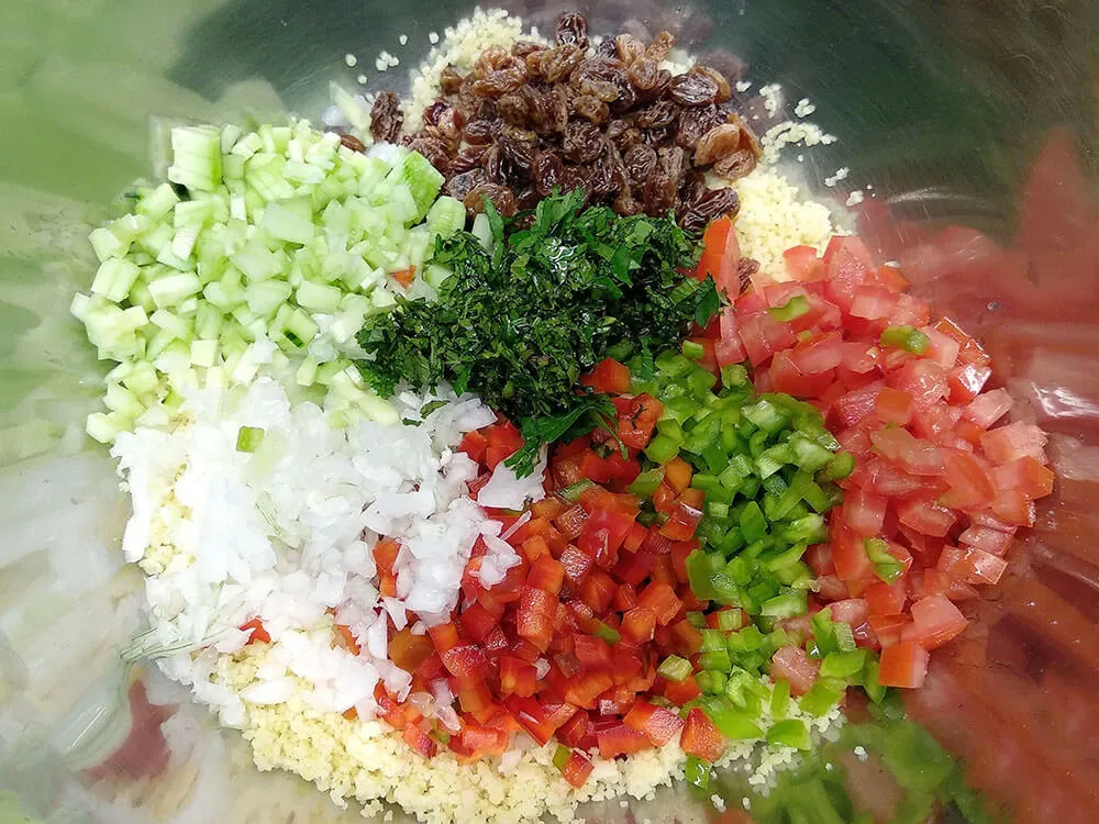 Cuscús, pepino, cebolleta, pimientos rojo y verde, tomate, menta y perejil.