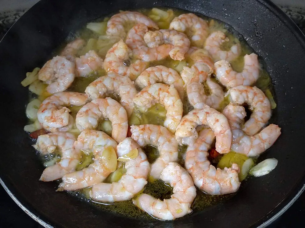 Langostinos, ajos laminados, guindilla salteados con chorrito de vermut.
