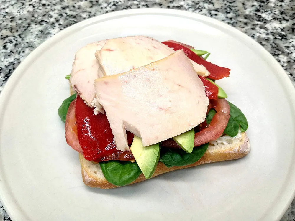 Chapata con mayonesa, espinacas baby, tomate,aguacate, piquillo y bonito en escabeche.